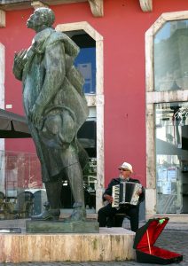 Frühstücksmusik - Der Straßenmusikant beim Sängerdenkmal in Leiria.